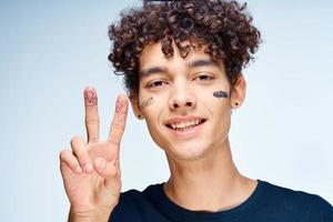 alegre hombre con Rizado pelo productos cosméticos en cara limpiar piel foto