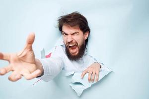 Emotional man stretches his hand forward looking through the wall of emotions office photo