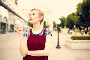 short haired woman outdoors fashion posing glass with drink photo