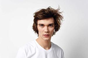 cute guy in white t-shirt tousled hair emotions posing photo