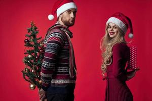 young couple christmas decorations holiday posing red background photo
