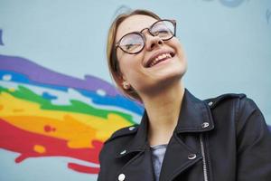 alegre mujer cuero chaqueta divertido emociones lentes y multicolor pintada foto