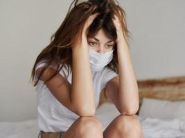 woman on vacation sitting on bed quarantine coronavirus pandemic photo