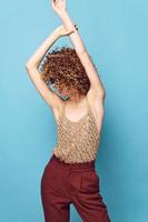 Attractive woman Curly hair hands over head movement fashionable clothes charm photo