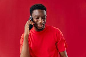man of african appearance talking on the phone red background photo