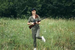 Woman Green jumpsuit shotgun hunting travel green leaves photo