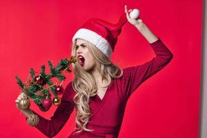 woman in red dress christmas tree toys holiday pink background photo