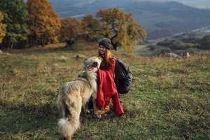 alegre mujer jugando con perro al aire libre montañas viaje vacaciones foto