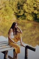 A hippie woman outdoors by the lake having fun in the fall photo