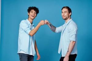 curly-haired guy in a shirt greets his friend on a blue background photo