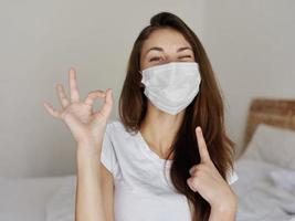 joyful woman showing finger to mask positive hand gesture photo