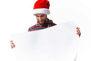 Cheerful man in New Year's clothes holding a banner holiday light background photo