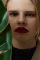 retrato de un mujer rojo labios palma hoja encanto Moda estudio modelo inalterado foto