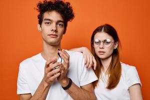 cheerful young couple wearing glasses emotion orange background fashion photo