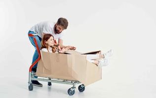 a man rolls a woman on a cargo cart in a box photo