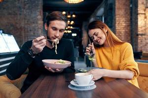 hombre y mujer sentado en café cena emociones divertido foto