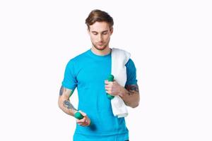 sporty man with dumbbells in hand, towel on shoulder doing exercises photo