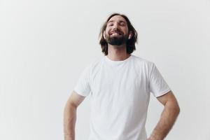 happy man listening to music and smiling in a white t-shirt on a white background happy photo