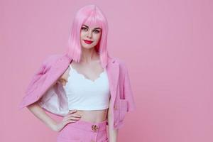 Young positive woman in a pink suit gesturing with his hands emotions fun pink background unaltered photo