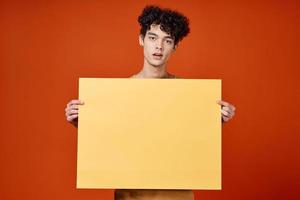 guy with curly hair island in hands advertising red background photo