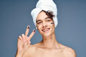 guy with bare shoulders with a towel on his head photo