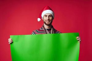 alegre hombre en un Papa Noel sombrero participación un bandera fiesta estudio posando foto