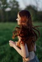 A happy athletic woman is jogging and smiling in nature in the park, summer sunset light photo