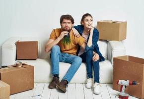 Young married couple room interior cardboard boxes moving photo