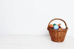 Pascua de Resurrección huevos en un cesta en un ligero antecedentes café espacio Días festivos regalos foto