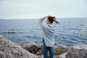 portrait of a woman sweaters cloudy sea admiring nature unaltered back view photo
