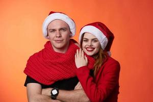 funny man and woman christmas santa hat friendship red background photo
