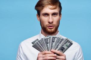 man holding wad of money near face wealth close-up studio photo