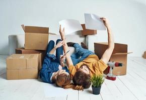 Portrait of man and woman with boxes moving plans for the future apartment photo