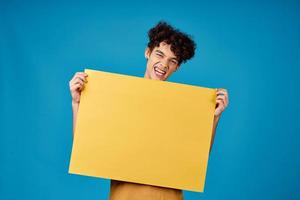 chico con amarillo póster en manos Copiar espacio publicidad azul antecedentes foto