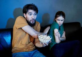 Offended woman on the couch in the evening watching TV and a man photo