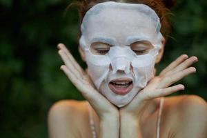 Beautiful woman with closed eyes shows tongue Anti-wrinkle mask dermatology photo