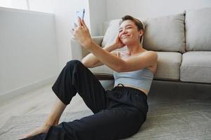 Woman blogger selfies on phone, selfies and online conversations for followers, teenager develops social media, freelancer from home photo