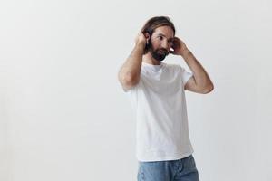 contento hombre escuchando a música y sonriente en un blanco camiseta en un blanco antecedentes contento foto