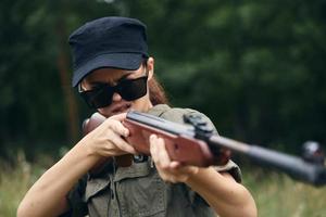 Woman soldier Aiming target hunting green leaves photo