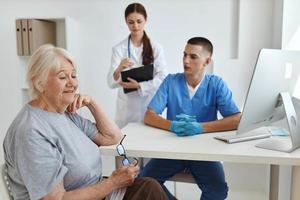 the doctor communicates with the patient with the nurse assistant diagnostics help photo