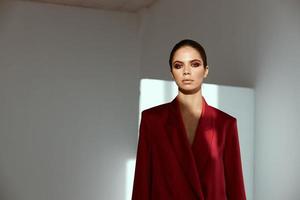 retrato de un morena con brillante maquillaje y un rojo chaqueta foto