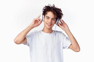 Rizado chico en auriculares escucha a música emociones entretenimiento foto