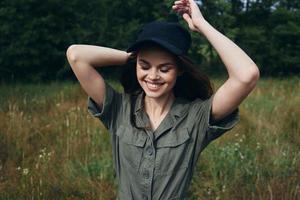 Woman outdoors Smile with closed eyes hands behind head black cap nature fresh air photo