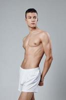 male with a naked torso athlete pumped up arm muscles and white shorts photo