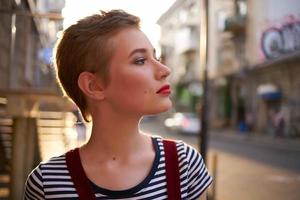 short haired woman wearing glasses outdoors walking posing photo