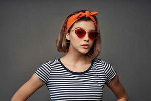 cheerful woman wearing sunglasses orange bandage on head isolated background photo
