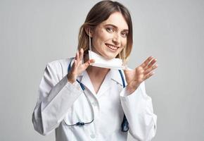 happy woman doctor in medical mask with stethoscope on neck photo