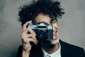 curly guy new technology camera studio gray background photo