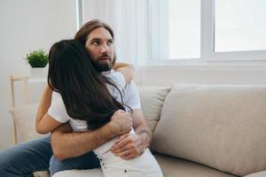 A man hugs his Asian woman friend at home. Psychological support for a friend photo