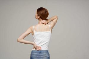 disgruntled woman pain symptoms in the joints arthritis light background photo